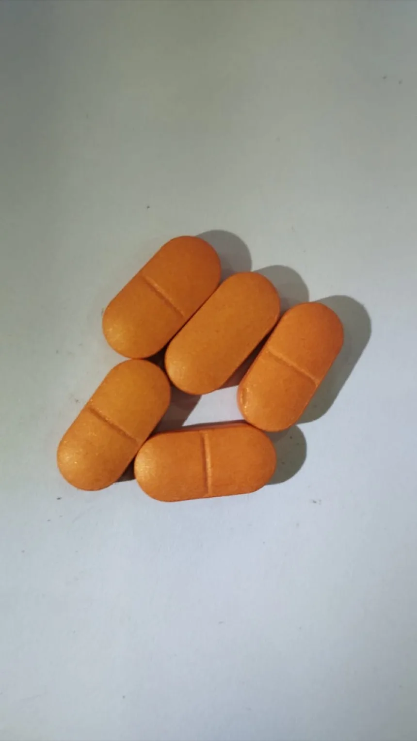 Orange aqueous film coated caplets with a clean break line